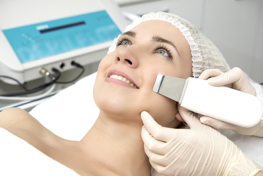 Female Laying on Table While Doctors Hands Measure Area of Treatment on Face