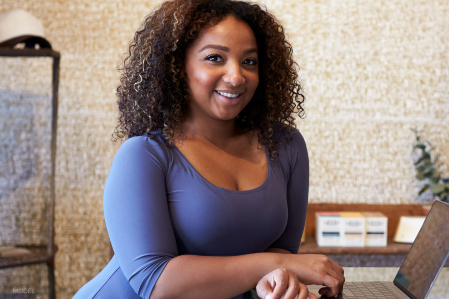 Woman Leaning Over Counter with Laptop